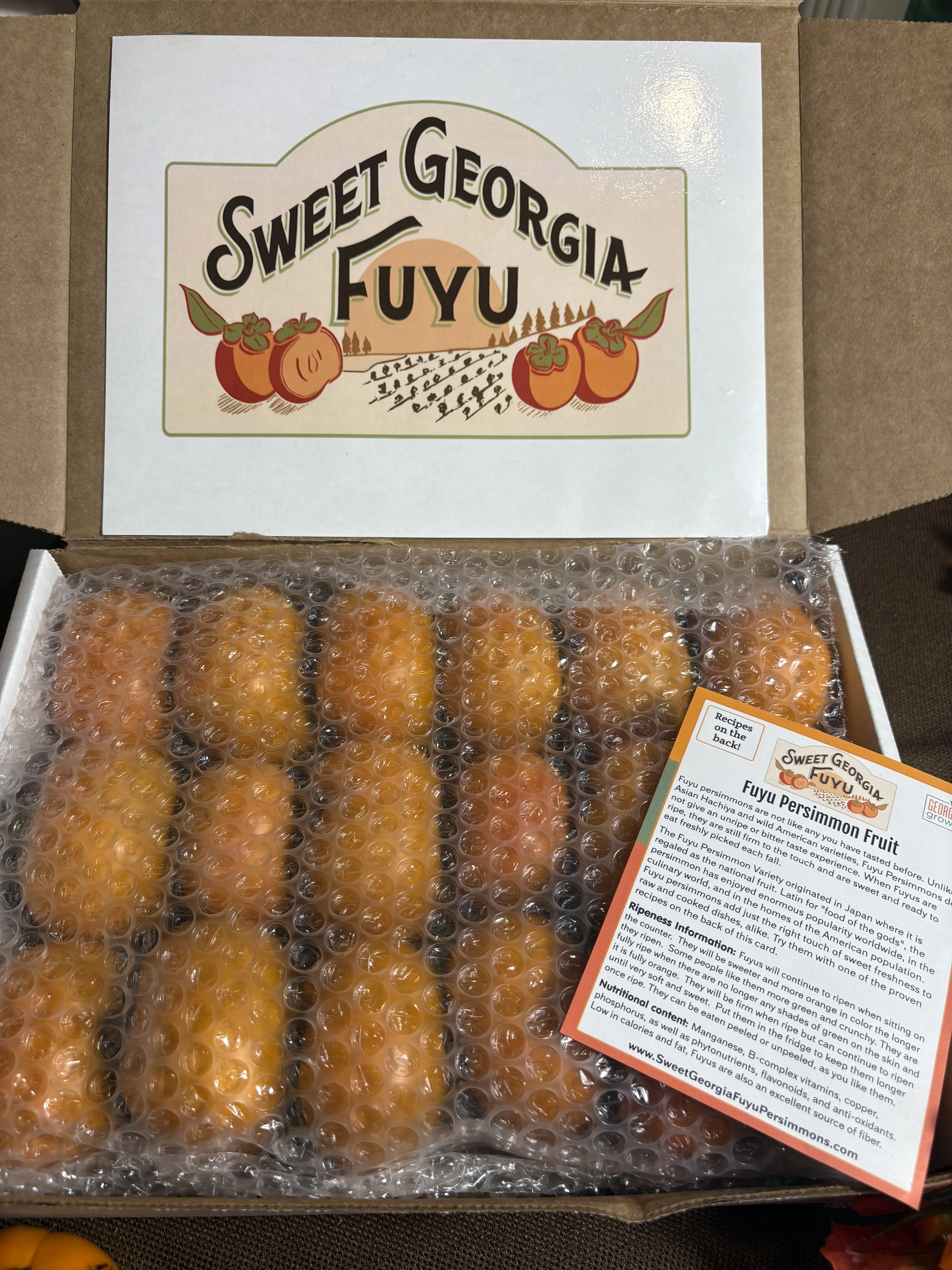 A frontal image of a box of fruit with a plastic cover for padding